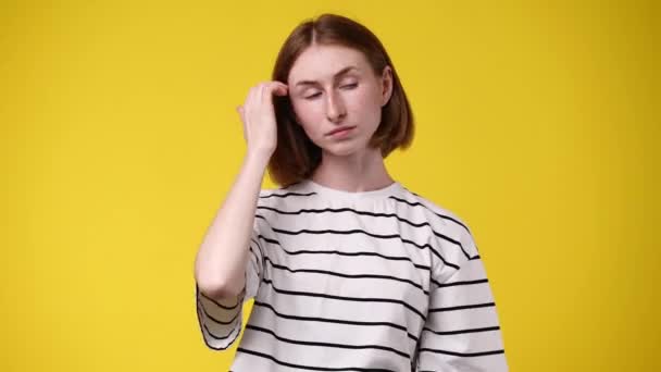1人の女の子の4Kビデオ私は彼の髪を修正し 黄色の背景の上に何かを考えます 感情の概念 — ストック動画