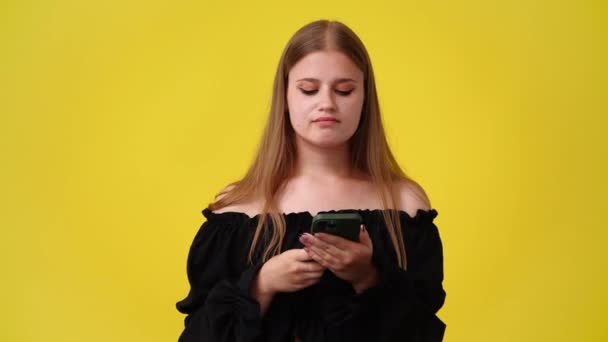 Wideo Jednej Dziewczyny Która Planuje Coś Telefonem Ręku Żółtym Tle — Wideo stockowe