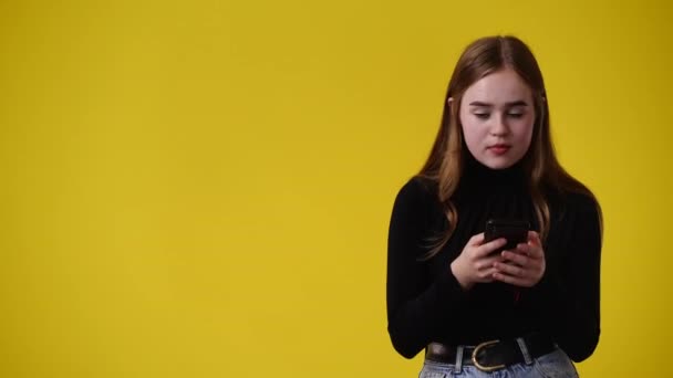 黄色の背景の上に左を指している1人の少女の4Kビデオ 感情の概念 — ストック動画