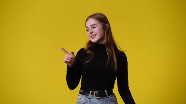 Video One Girl Pointing Right Yellow Background Concept Emotions — ストック動画