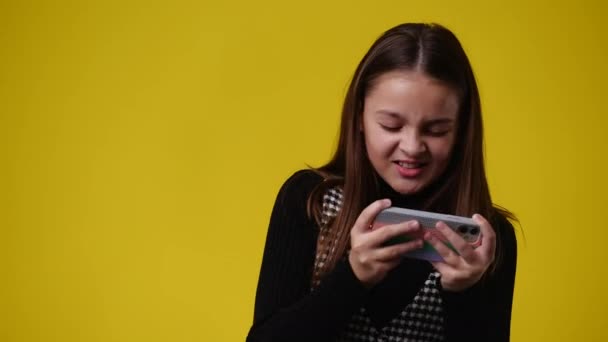 Sarı Arka Planda Telefonu Kullanan Hoş Bir Kızın Videosu Duyguların — Stok video