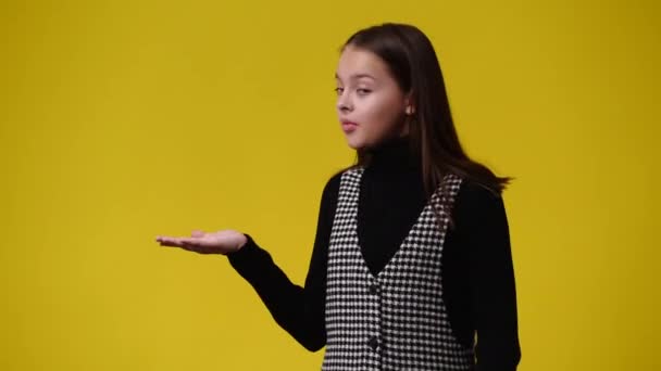 一个女孩指着黄色背景的4K视频 情绪的概念 — 图库视频影像