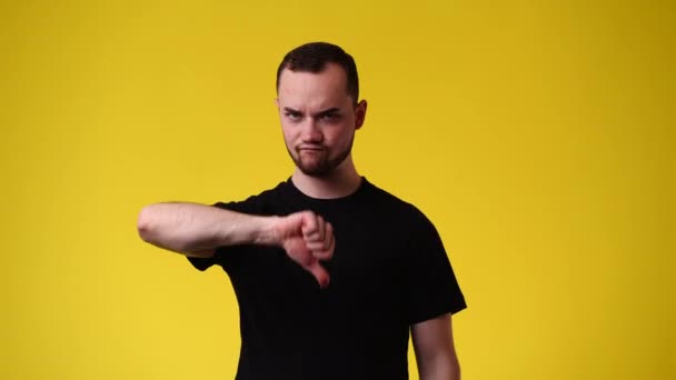 Video Hombre Mostrando Pulgar Hacia Abajo Sobre Fondo Amarillo Concepto — Vídeos de Stock