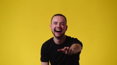 Sarı arka planda gülümseyen adamın 4K videosu. Duyguların kavramı.