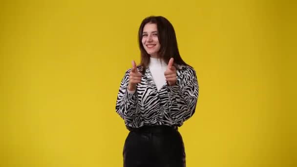 黄色の背景にOkの看板を見せる可愛い女の子の4K動画 感情の概念 — ストック動画