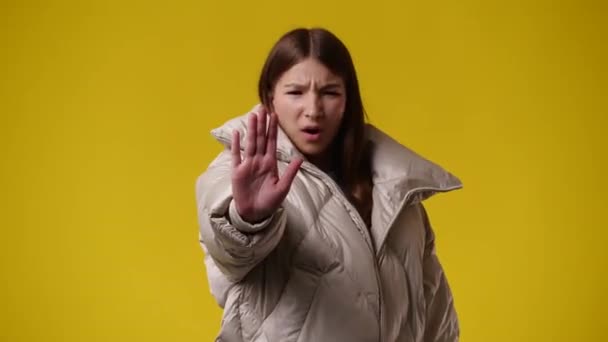 一个女孩在黄色背景上显示停车标志的4K视频 情绪的概念 — 图库视频影像