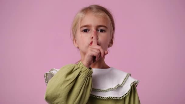 ピンクの背景に無音サインを示す1人の少女の4K動画 感情の概念 — ストック動画
