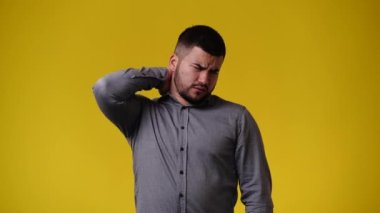 Sarı arka planda negatif yüz ifadesi olan bir adamın 4K videosu. Olumsuz duygu kavramı.