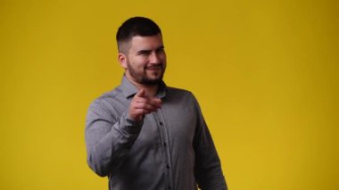 4k video of one man posing for a video over yellow background. Concept of emotions.
