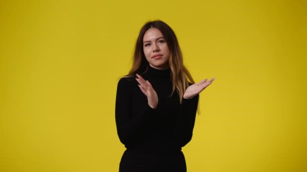 黄色の背景に不確実性のある1人の少女の顔の表情の4Kビデオ 感情の概念 — ストック動画