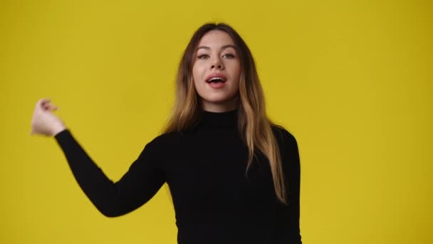 黄色の背景の上に親指を示す1人の少女の4Kビデオ 感情の概念 — ストック動画