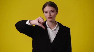 Sarı arka planda başparmağını gösteren 4K video. Olumsuz duygu kavramı.