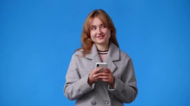 4k video of one girl sending messages on blue background. Concept of emotions.