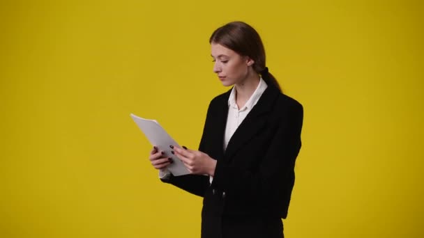 Bir Kızın Heyecanlandığı Sarı Arka Planda Kağıtları Gösteren Videosu Duyguların — Stok video