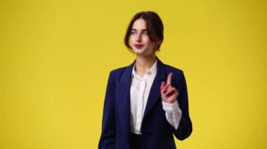 Sarı arka planda duran bir kızın 4K videosu. Duyguların kavramı.