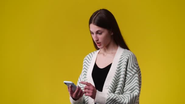 Vídeo Uma Garota Que Assiste Vídeos Seu Telefone Sorri Sobre — Vídeo de Stock