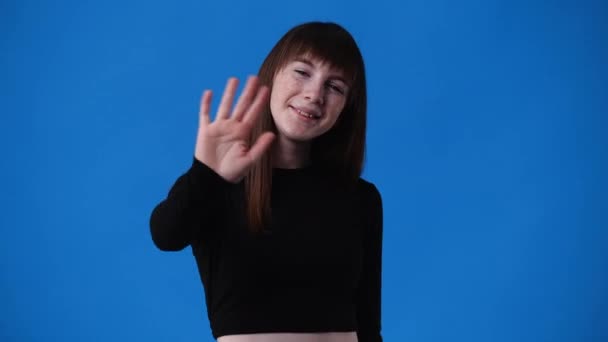 Zpomalené Video Jedné Dívky Pozdravit Někoho Přes Modré Pozadí Pojetí — Stock video