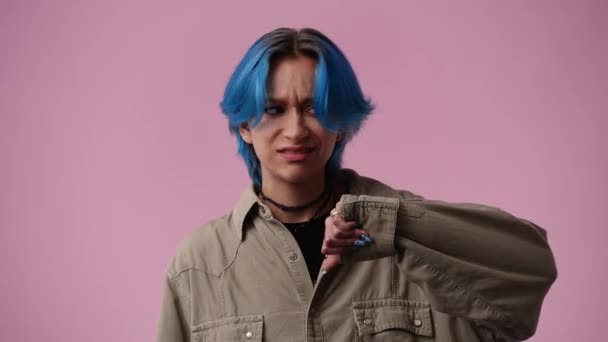 4時間のスローモーションビデオの1人の女の子の否定的な表情は ピンクの背景の上に親指を示しています 感情の概念 — ストック動画