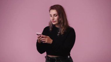 Pembe arka planda mesaj yazan ve gülümseyen bir kadının 4K videosu. Duyguların kavramı.