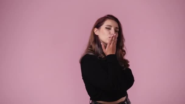 Video Kvinna Ler Och Skickar Kyss Luft Över Rosa Bakgrund — Stockvideo