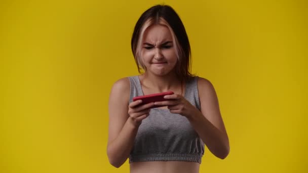 Wideo Jednej Dziewczyny Gra Telefonie Żółtym Tle Pojęcie Emocji — Wideo stockowe