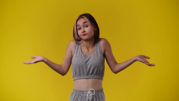 Video Genç Bir Kızın Sarı Arka Planda Elini Sallamasını Gösteriyor — Stok video