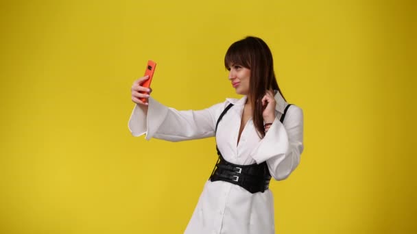 Wideo Cute Girl Pomocą Telefonu Machając Cześć Nad Żółtym Tle — Wideo stockowe