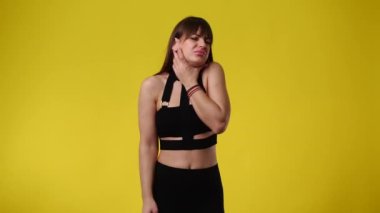 Sarı arka planda poz veren bir kızın 4K videosu. Duyguların kavramı.