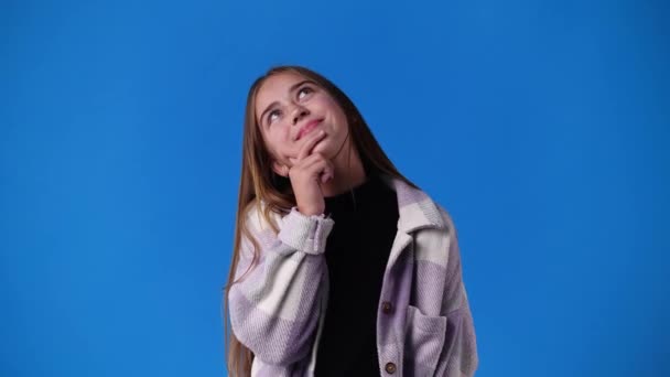 Bir Kızın Mavi Arka Planda Bir Şeyler Düşündüğü Video Duyguların — Stok video
