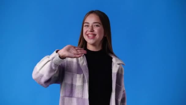 Video Van Schattig Meisje Glimlachen Zwaaien Hallo Blauwe Achtergrond Concept — Stockvideo