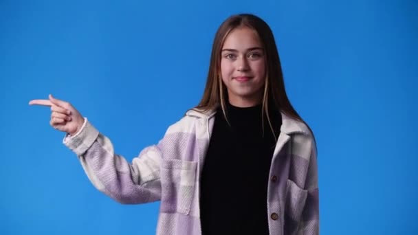 Vídeo Uma Garota Apontando Para Elevador Mostrando Polegares Fundo Azul — Vídeo de Stock