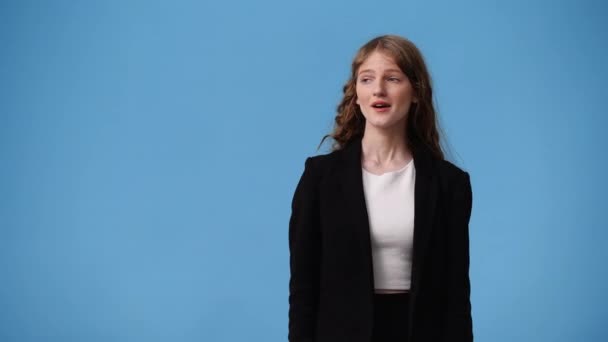 Video Van Een Meisje Wijst Naar Links Blauwe Achtergrond Concept — Stockvideo