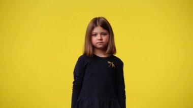 4k video of cute girl smiling over yellow background. Concept of emotions.