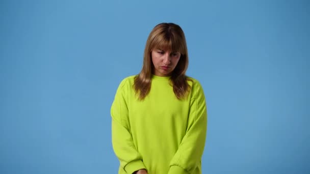 4Kビデオの1人の女の子の否定的な表情が青の背景にあります 感情の概念 — ストック動画