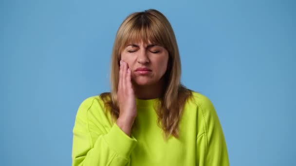 青い背景に歯痛のある1人の女の子の4Kビデオ 感情の概念 — ストック動画