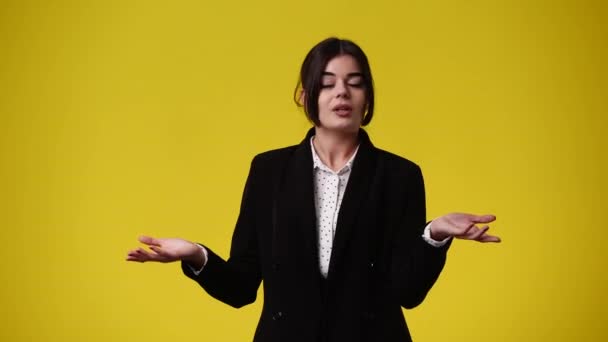 Wideo Dziewczyny Która Emocjonalnie Mówi Rękami Skierowanymi Boki Żółtym Tle — Wideo stockowe