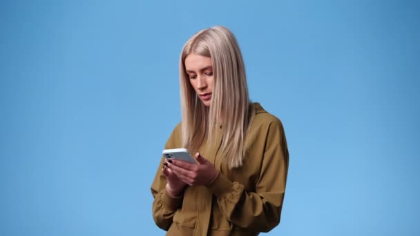 Vídeo Uma Mulher Que Digita Texto Telefone Sobre Fundo Azul — Vídeo de Stock