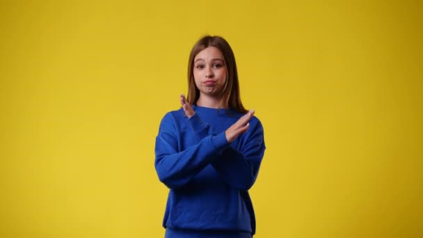 4K慢镜头 一个女孩在黄色背景下拦住了一个面部表情消极的人 情绪的概念 — 图库视频影像