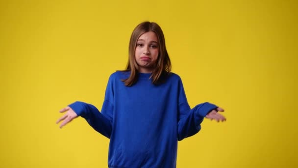 Video Genç Bir Kızın Sarı Arka Planda Elini Sallamasını Gösteriyor — Stok video