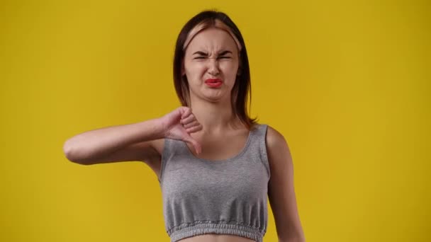 Video Pige Med Negativt Ansigtsudtryk Viser Tommelfinger Ned Gul Baggrund – Stock-video