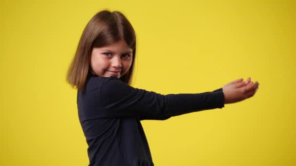 黄色の背景に手に何かを持っている1人の子供の4Kビデオ 感情の概念 — ストック動画