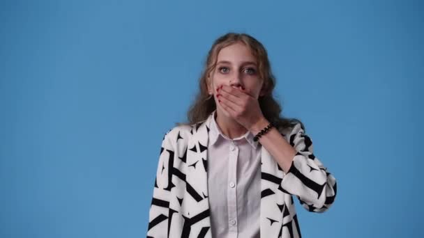 Wideo Jednej Dziewczyny Która Zaskoczyła Włożyła Rękę Ust Niebieskim Tle — Wideo stockowe