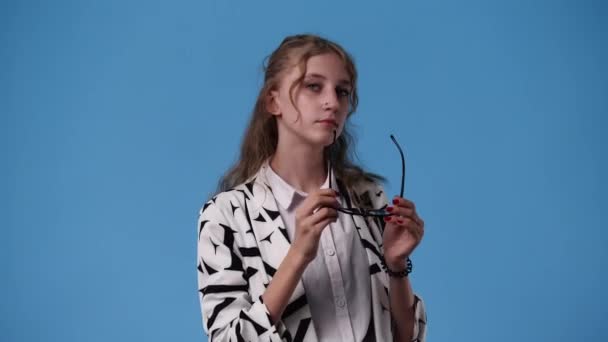 Mavi Arka Plan Üzerine Gözlük Takan Bir Kızın Videosu Duyguların — Stok video
