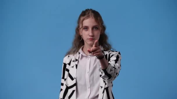 青を背景に沈黙の手サインを見せる1人の少女の4K動画 感情の概念 — ストック動画