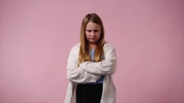 4k video of one girl with negative facial expression over pink background. Concept of emotions.