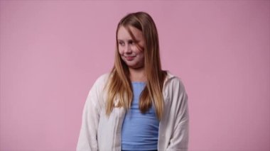 4k video of one girl posing for a video over pink background. Concept of emotions.