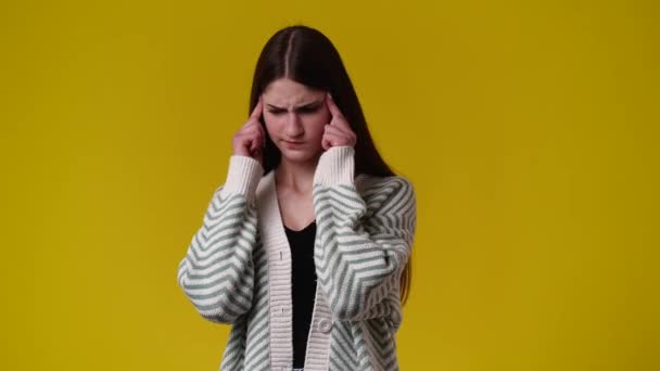 黄色い背景の上に頭痛のある1人の少女の4Kビデオ 感情の概念 — ストック動画