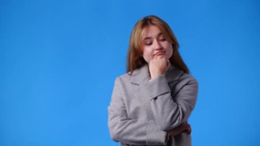 4k video of a woman thinking about something blue pink background. Concept of emotions.