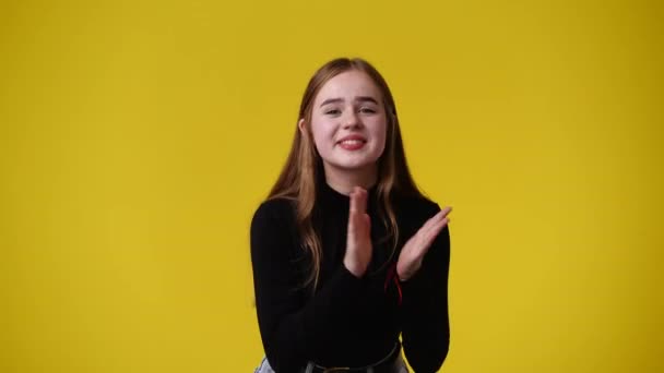 Video Jenter Som Klapper Med Slu Ansiktsuttrykk Gul Bakgrunn Følelsesbegreper – stockvideo