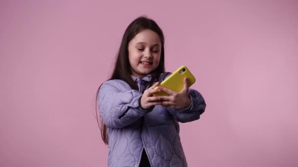 Video Cute Girl Using Phone Pink Background Concept Emotions — Stock video